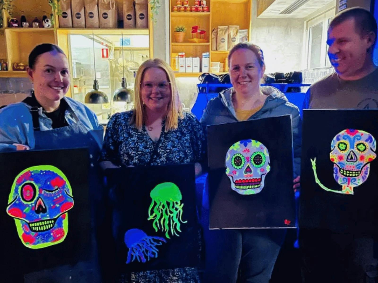 Guests holding their Neon Sugar Skull artworks