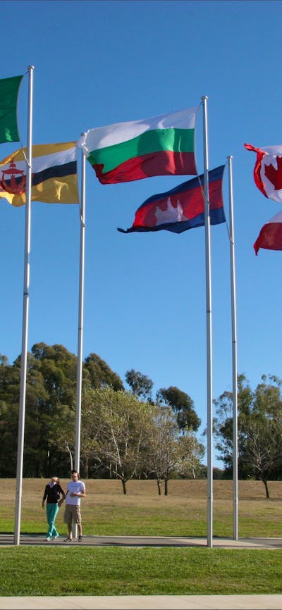 Couple walking underneath international flags