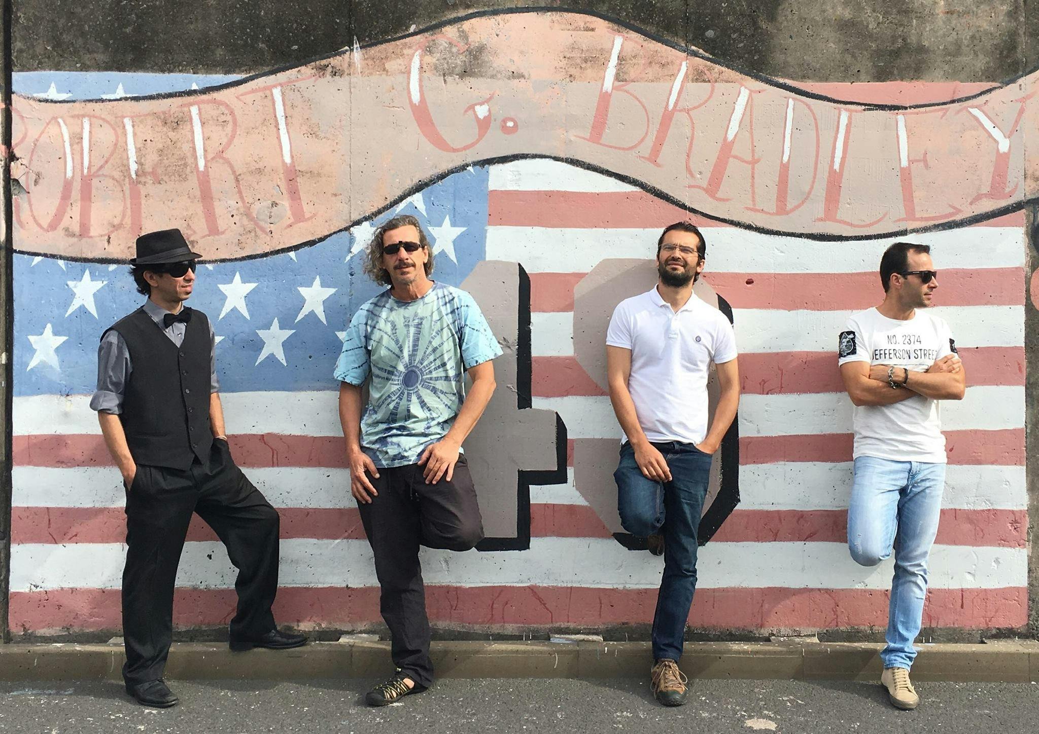 Black Dog Blues band photo, all for leaning back against faded street at of the USA Flag.