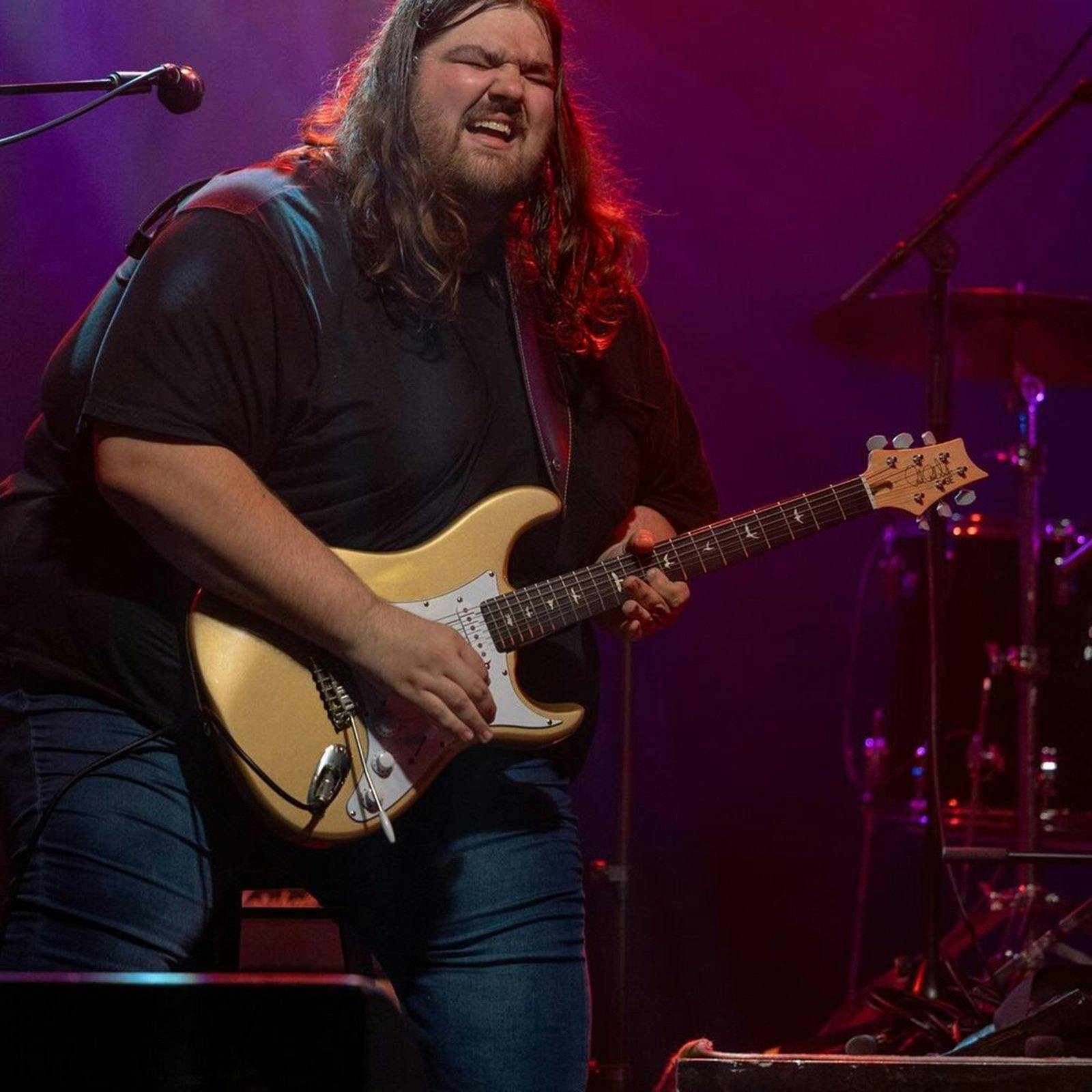 A man standing with a guitar