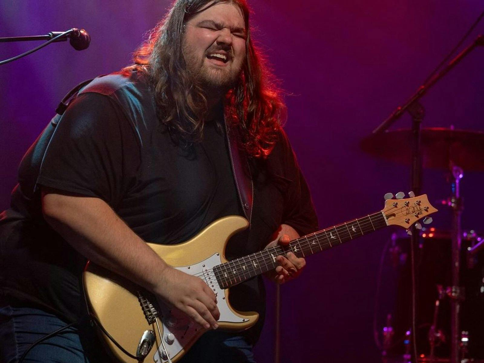A man standing with a guitar