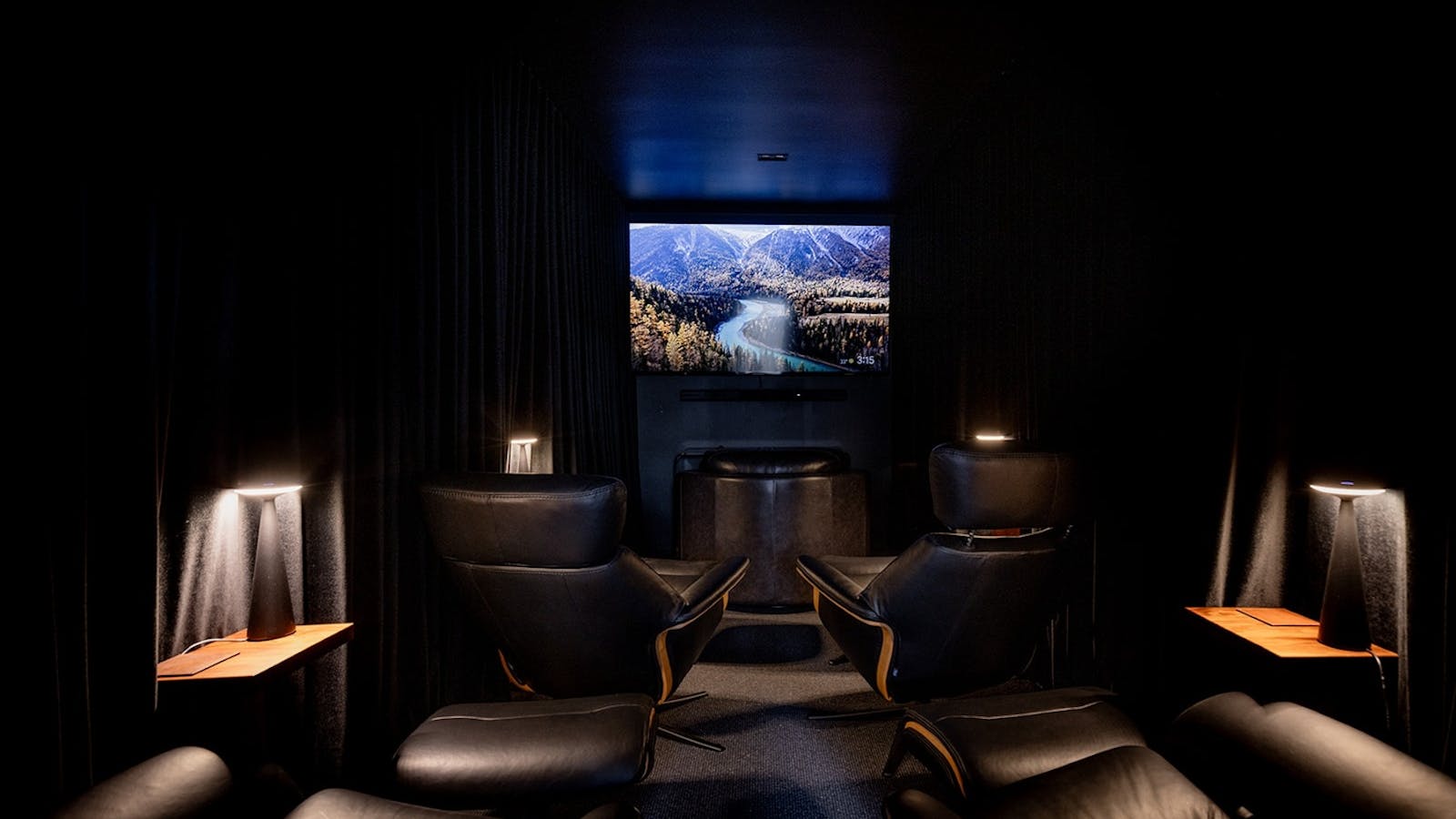 Private cinema room with reclining chairs and immersive screen for a luxury movie experience.
