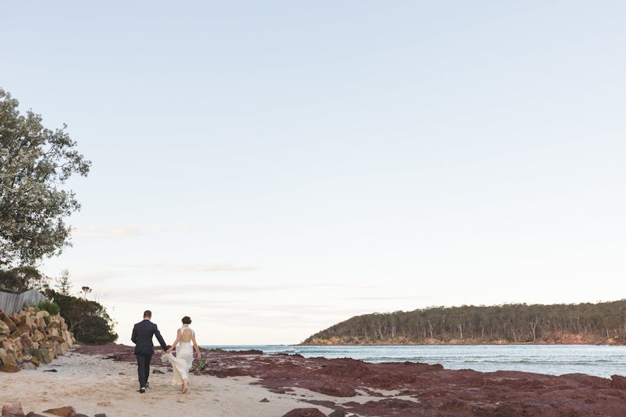 Newly weds walking along the beach