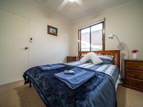 Bedroom 1 features a queen bed with superior linen, bedside tables , reading lamps and a ceiling fan