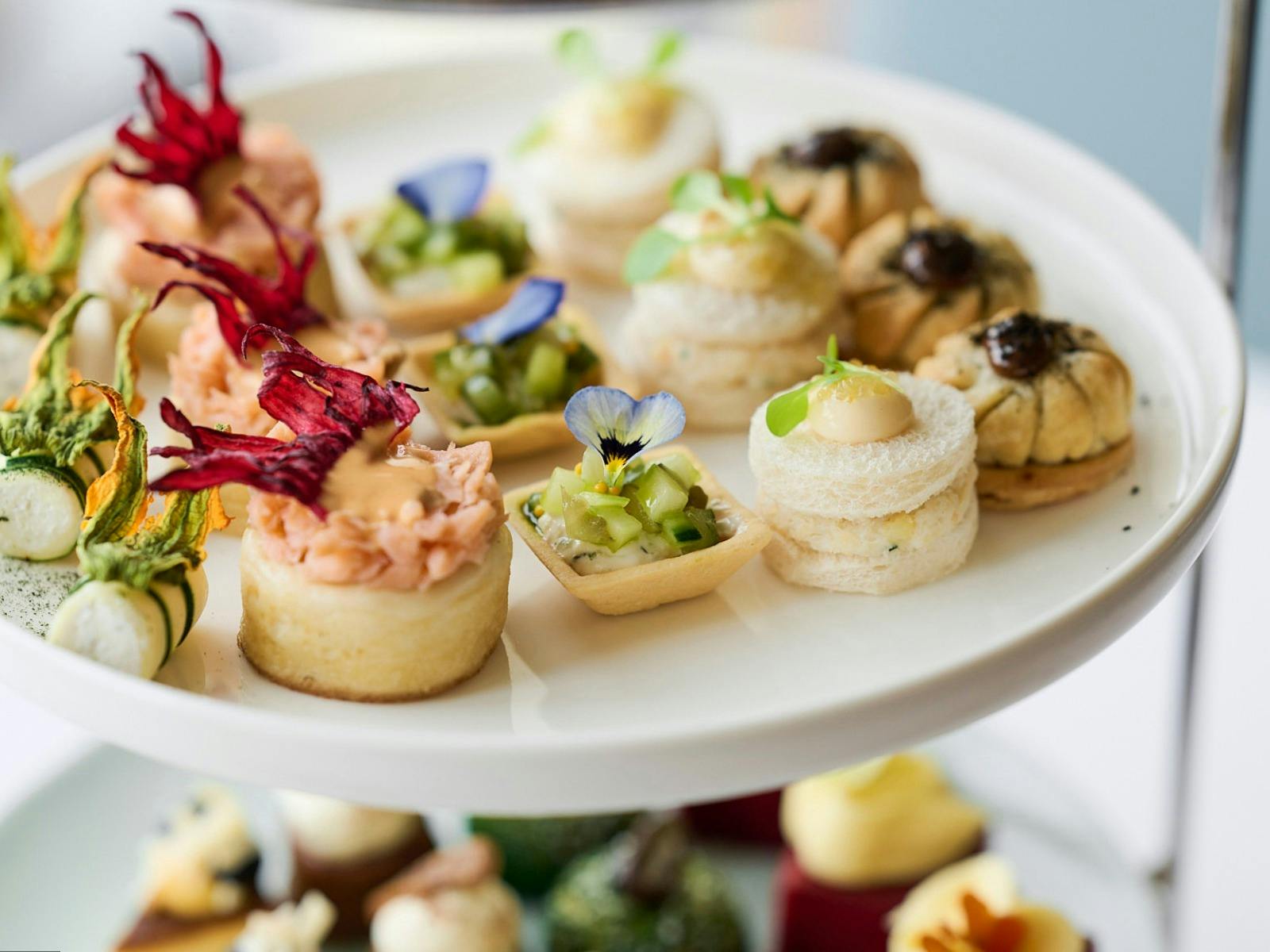 Close up of plated of small high tea items such as cakes and tarts