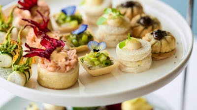 Close up of plated of small high tea items such as cakes and tarts