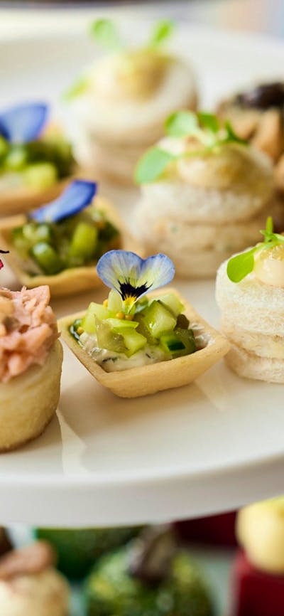 Close up of plated of small high tea items such as cakes and tarts
