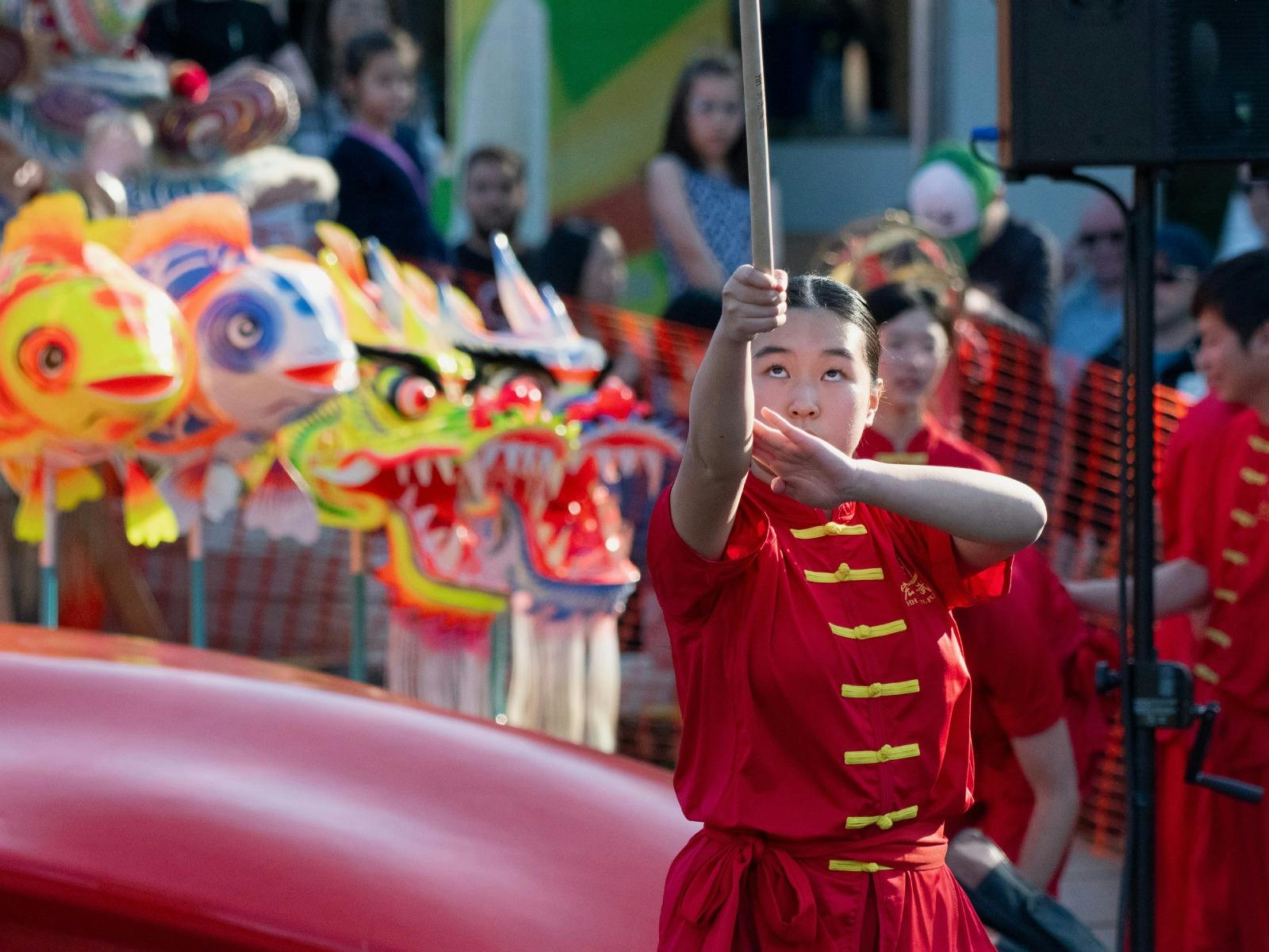 A girl wearing red demonstrating traditional martial arts