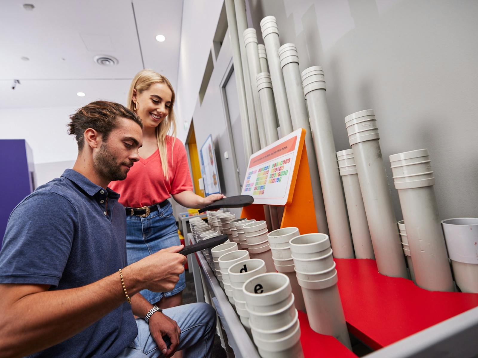Young man and woman playing with Sciencentre interactive