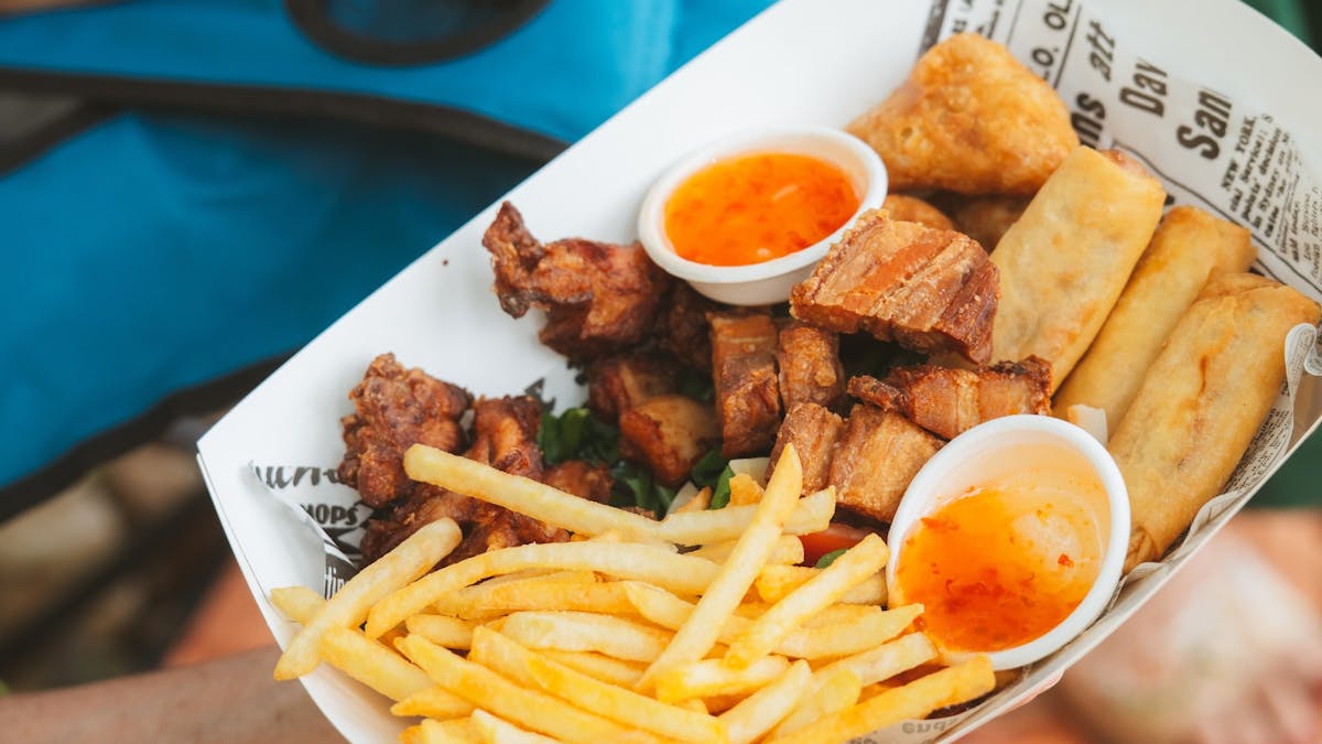 Close up of a cardboad takeaway boat containing food.
