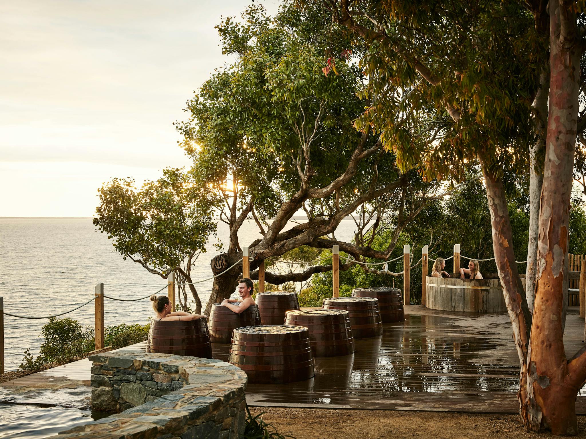 People enjoying geothermal hot springs bathing and views over the Gippsland Lakes
