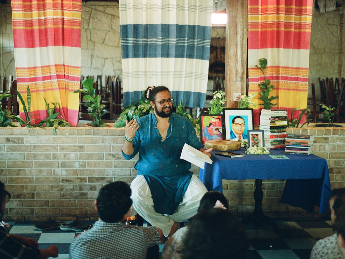 Photograph of Vamsi performing 'Come Eat With Me' in fromnt of audience.