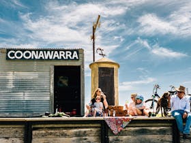 Kids and Adults sit infront of the Coonawarra Siding along the Rail Trail