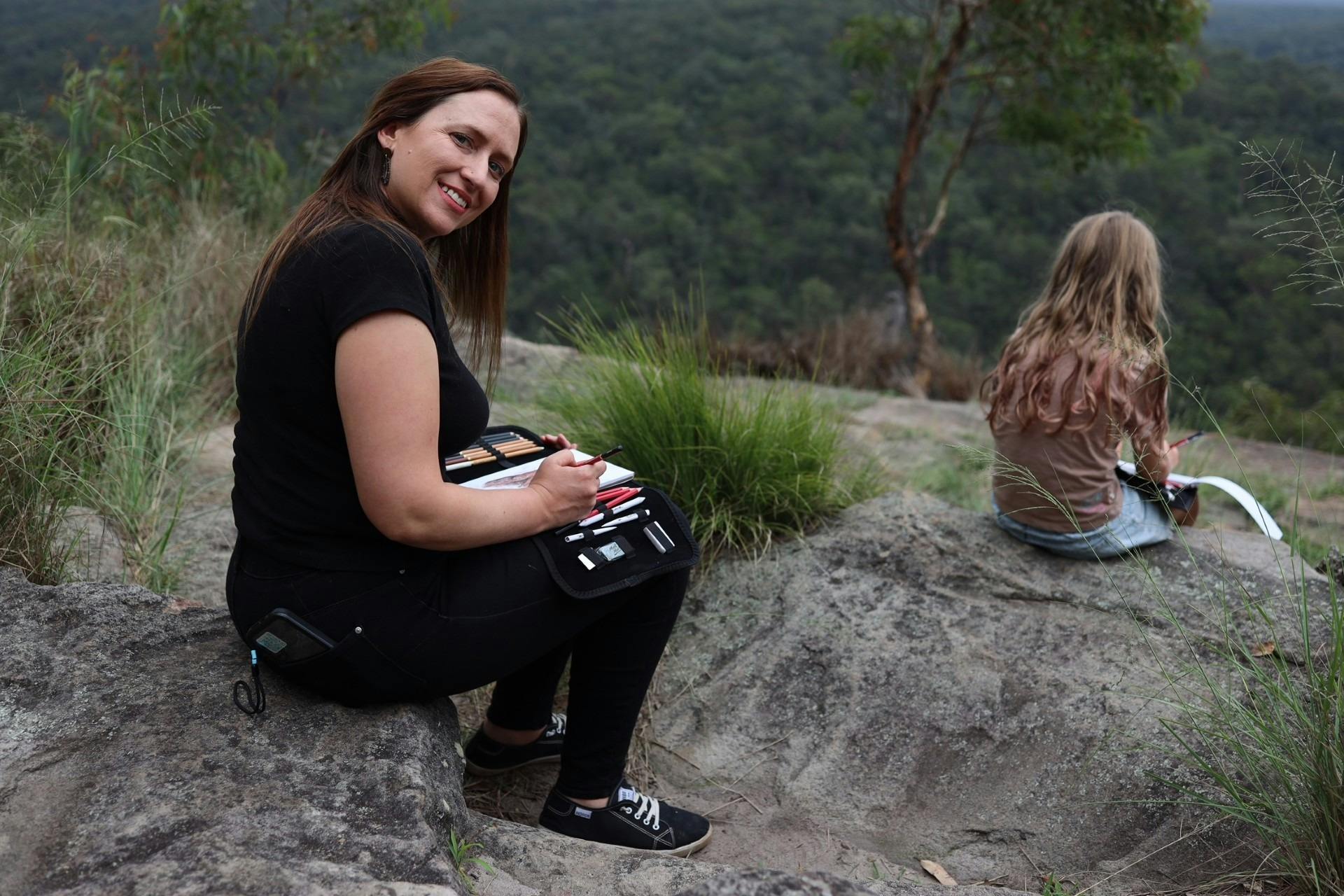 Lady at lookout doing charcoal drawing being mindful