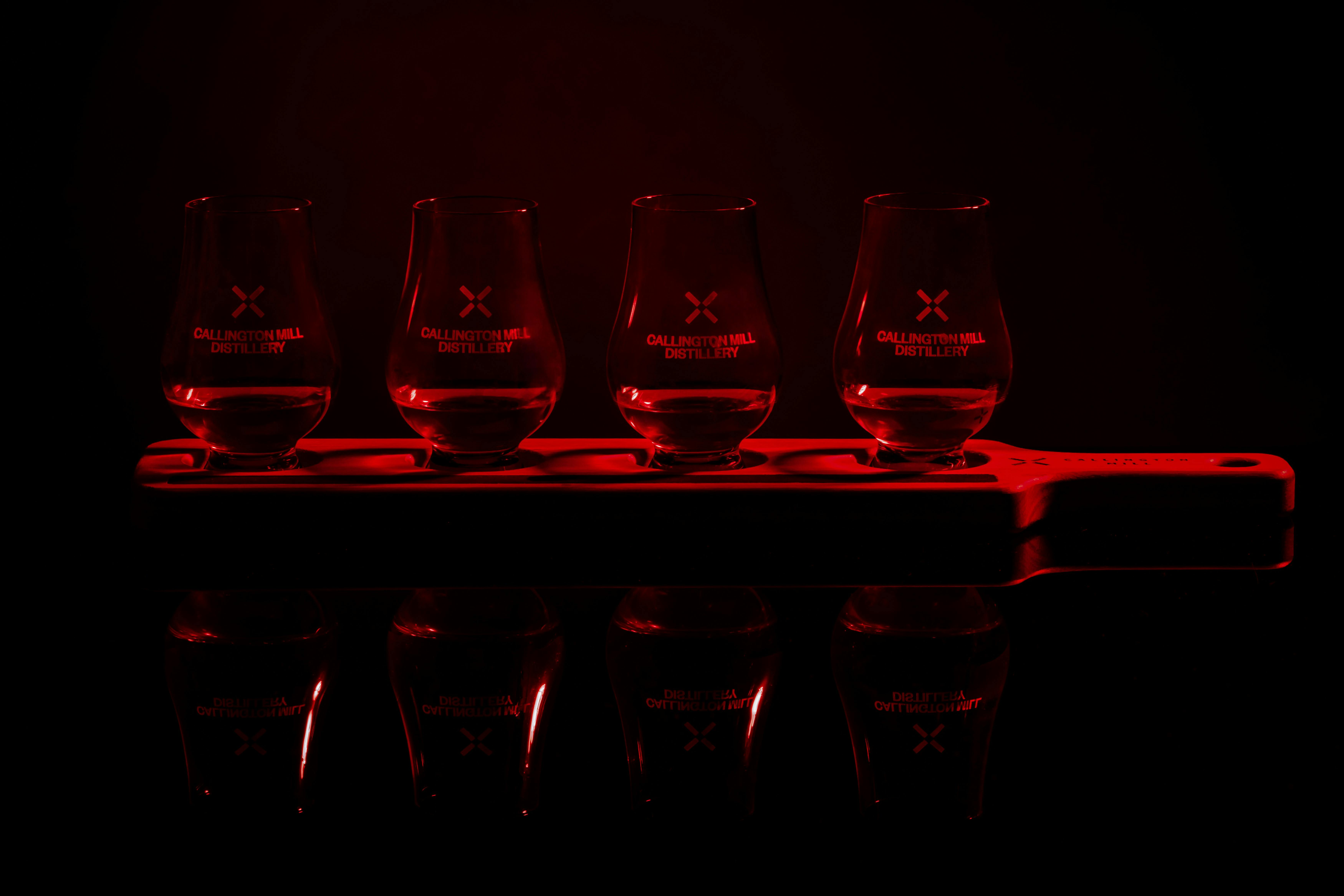 A paddle of whisky tastings in the dark, barely lit by red light