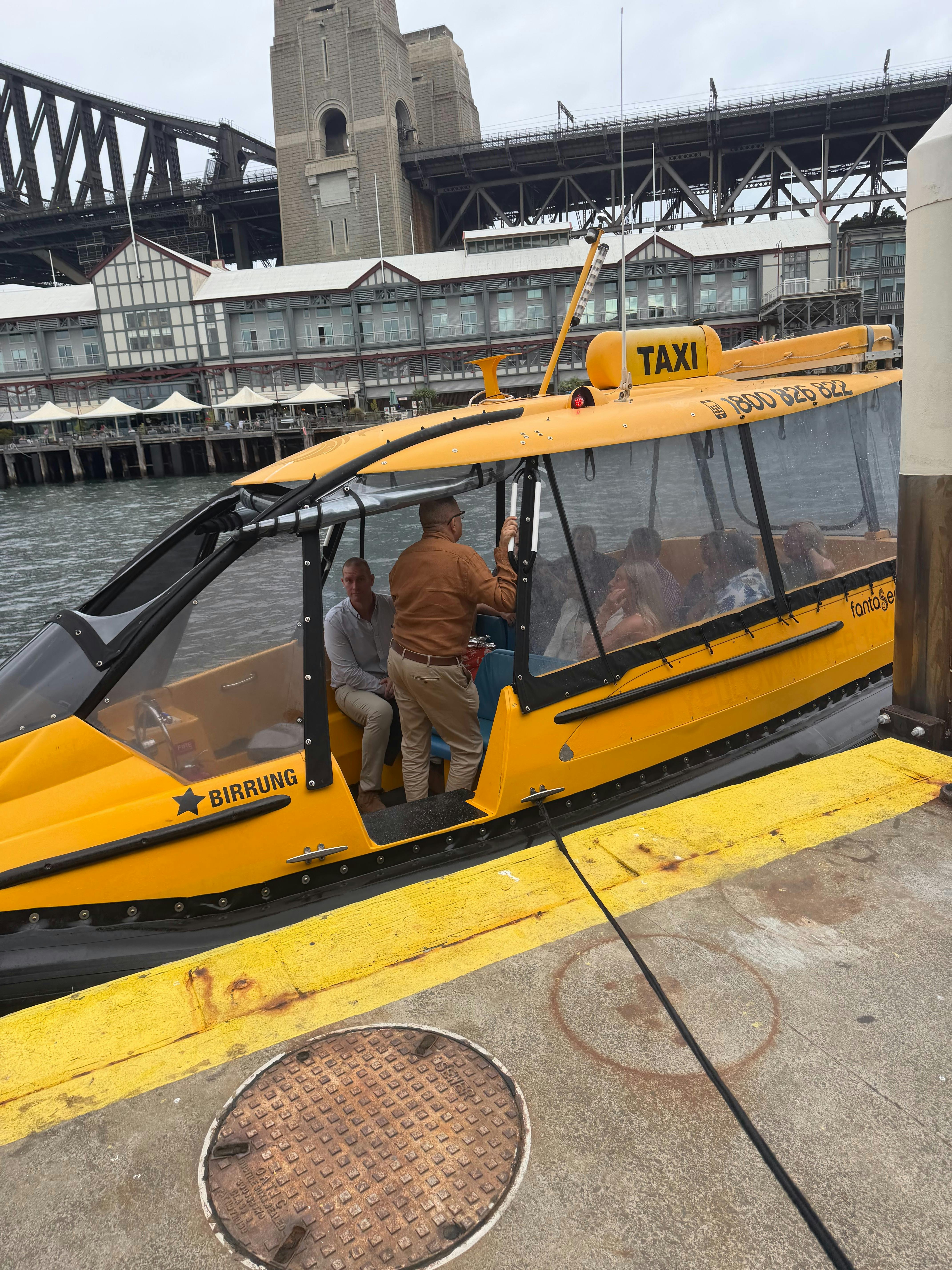 Passengers stepping aboard a water taxi at a Sydney Harbour public wharf.