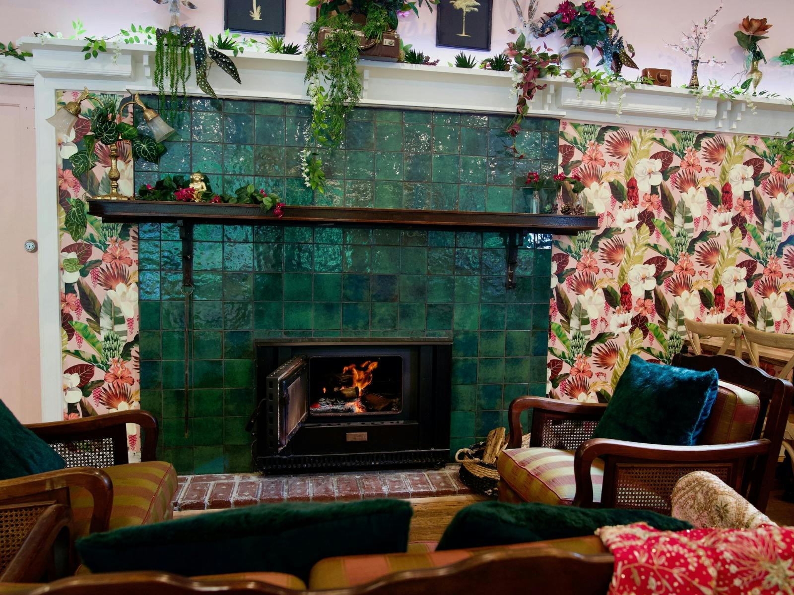 An open fire sits within an art deco fireplace
