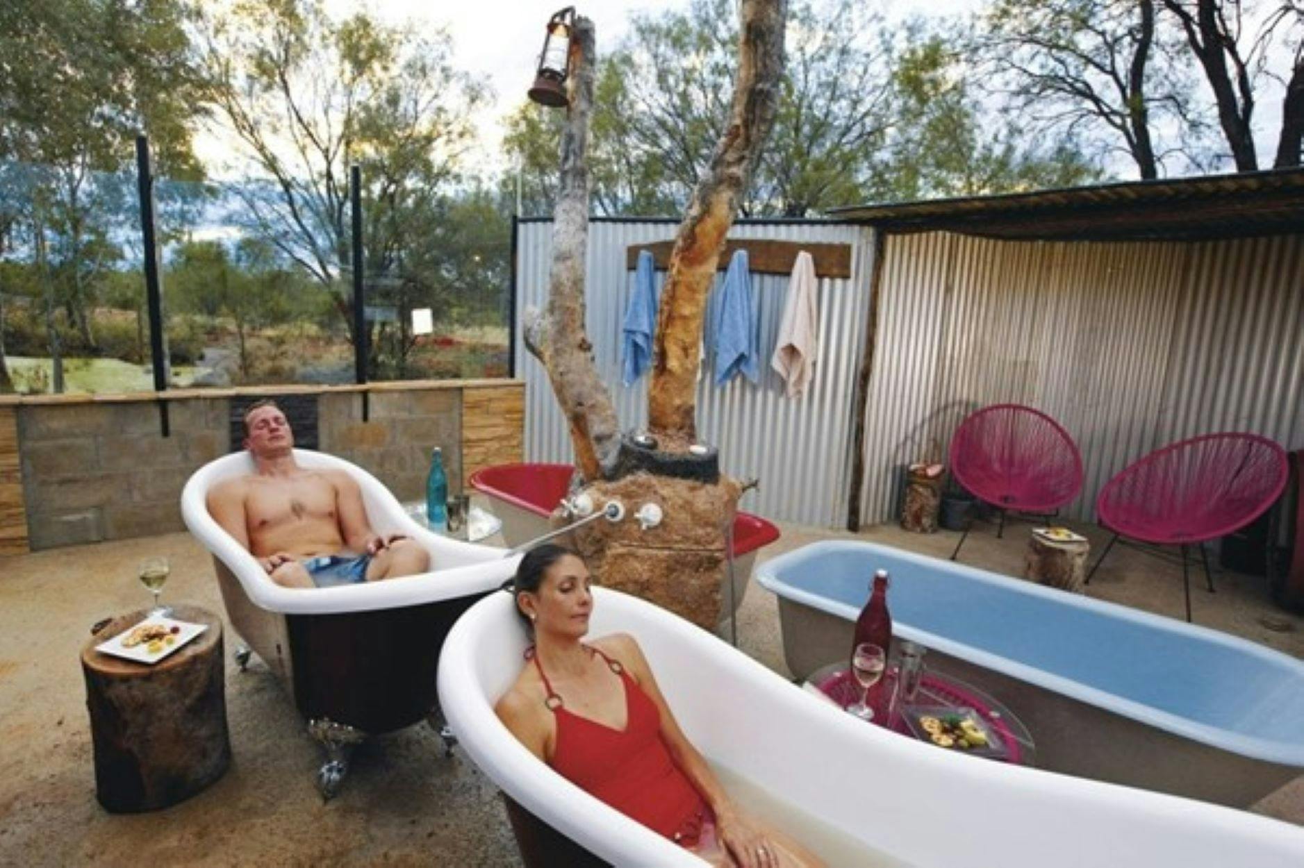 Man and Woman relax in baths filled with milky grey artesian mud waer