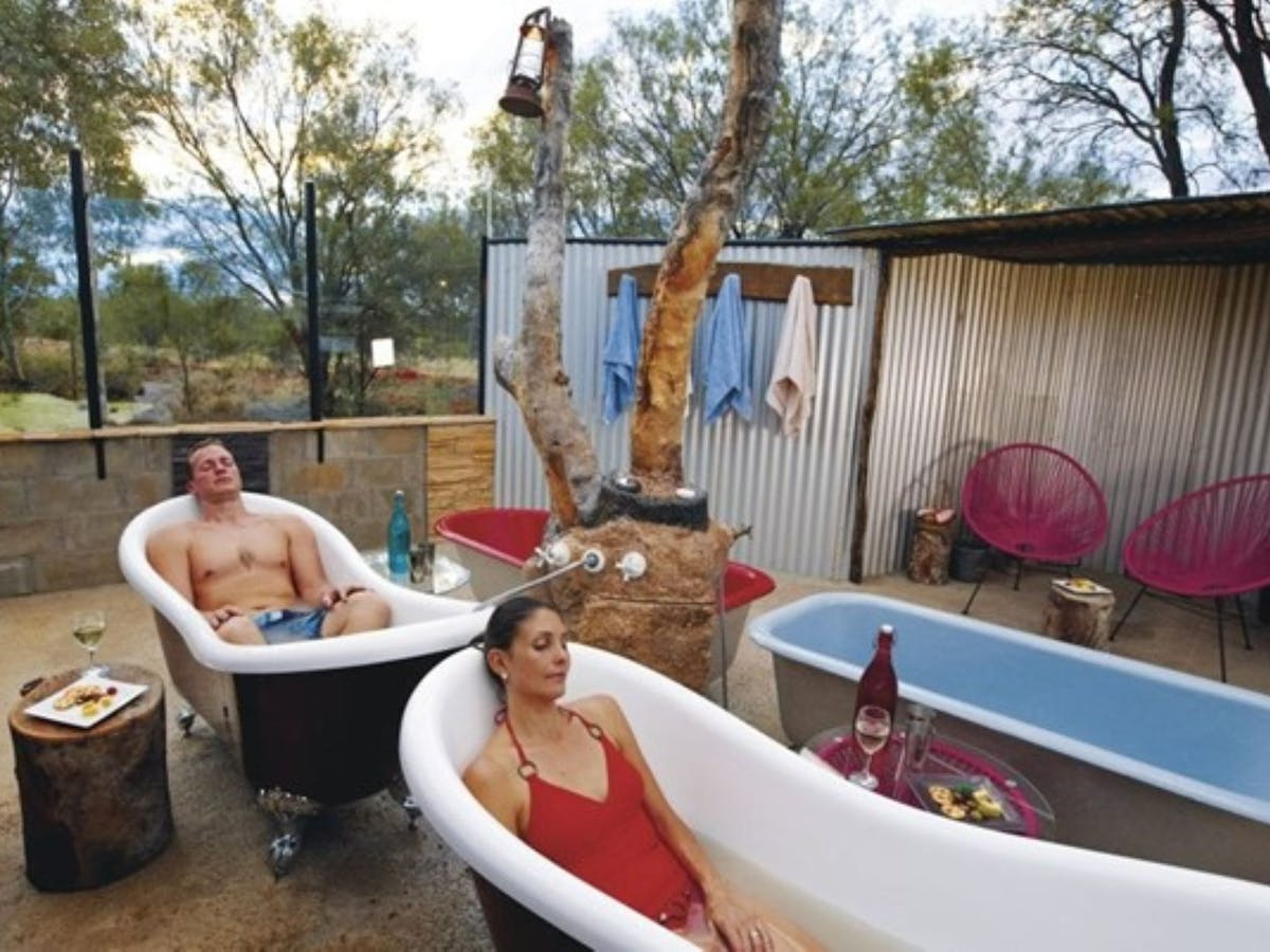 Man and Woman relax in baths filled with milky grey artesian mud waer Man and Woman relax in baths filled with milky grey artesian mud waer