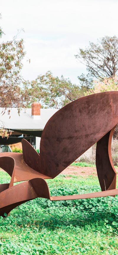 An abstract steel sculpture of geometric forms with a rusty patina in the garden.