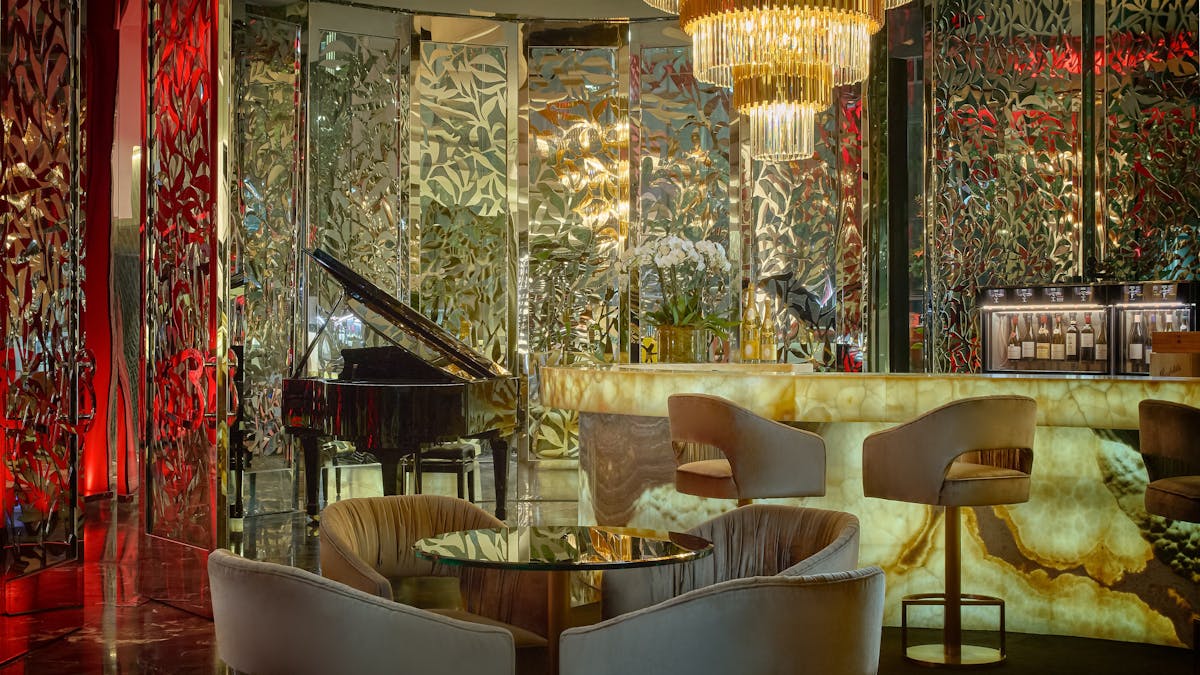 Luxurious wine bar with glowing onyx bar, velvet seating and a grand piano