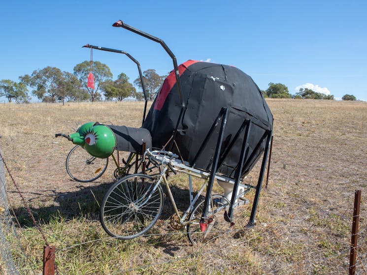 A very large redback spider riding two drop barred road bicycles.