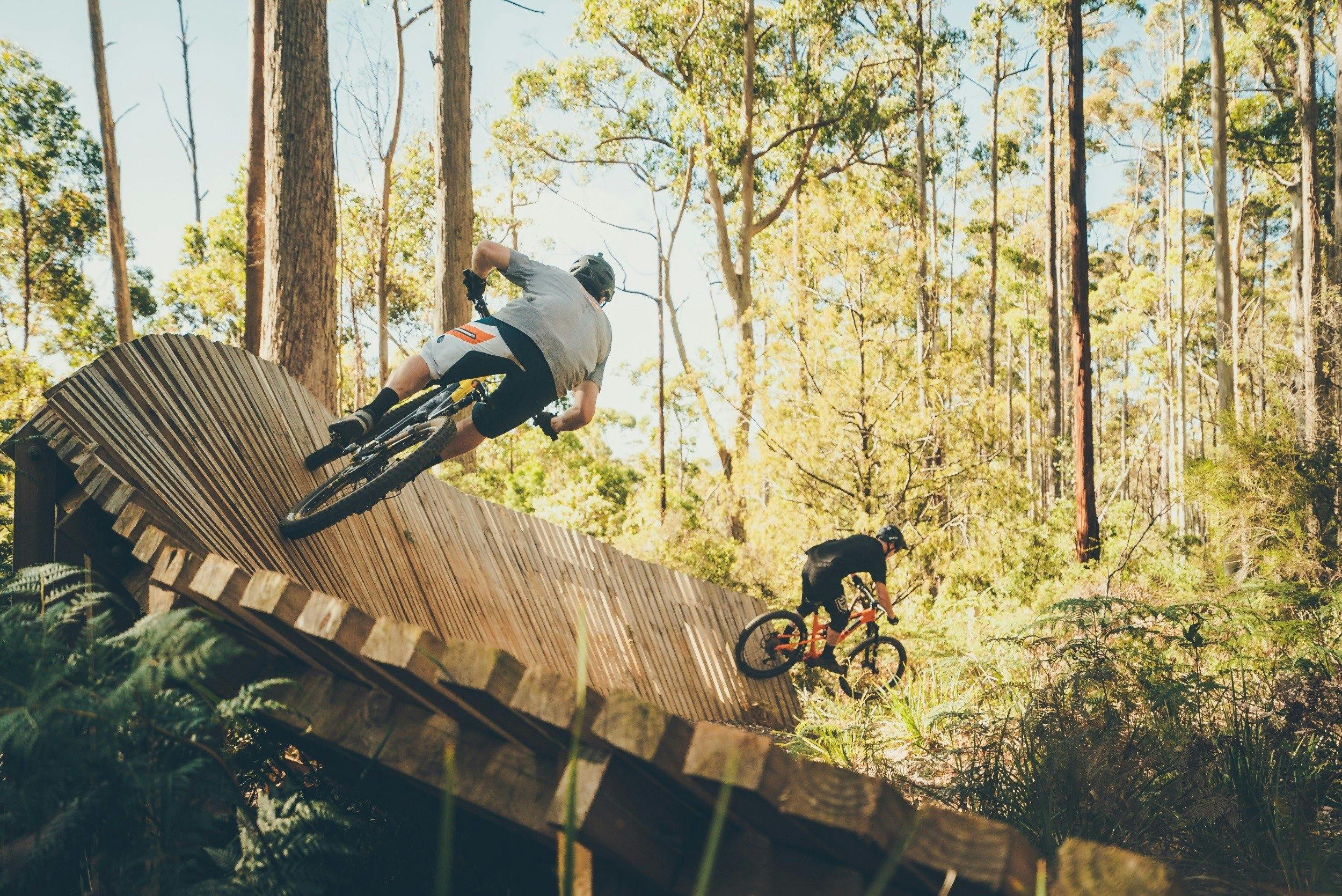 men riding mountain bikes on wooden obsticles