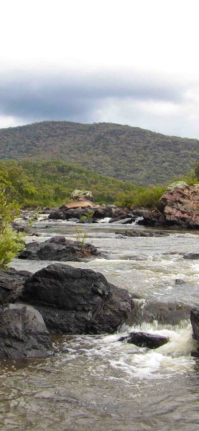A picture of a waterwatch with rocks and hills in the background
