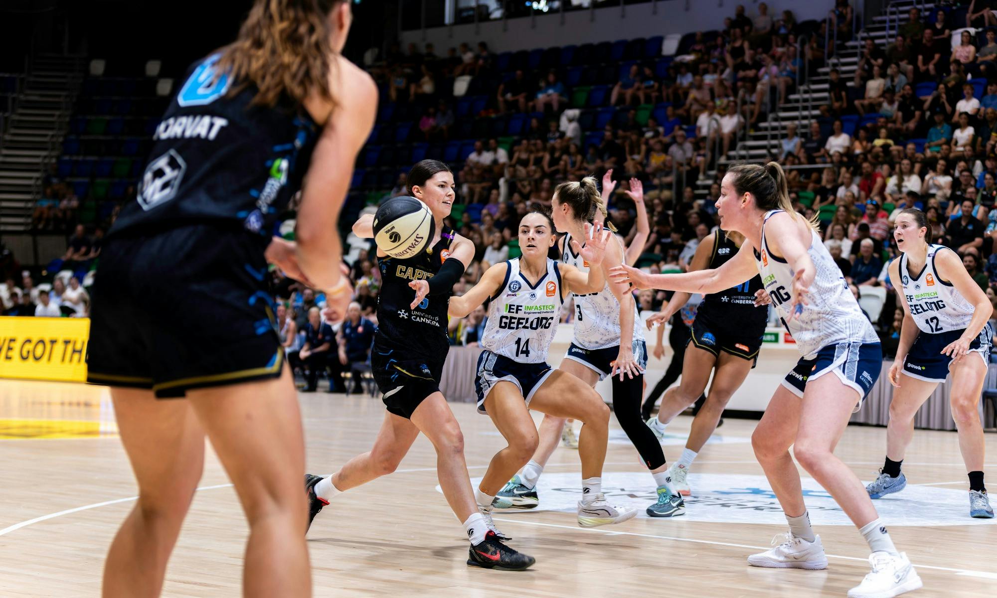 UC Capitals player passing the basketball during a game.