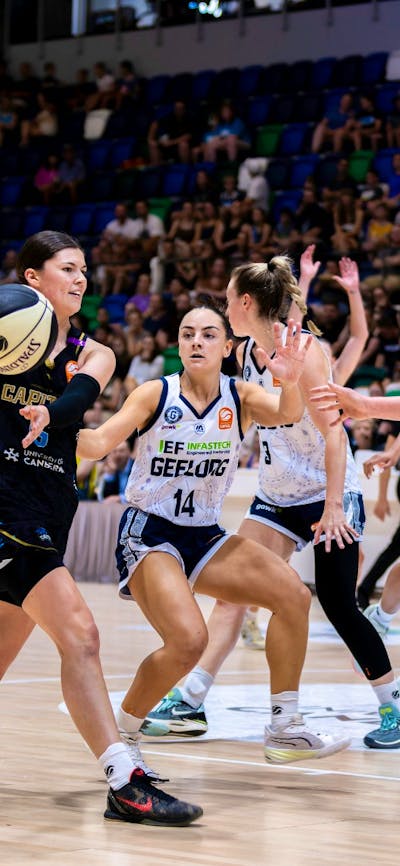 UC Capitals player passing the basketball during a game.