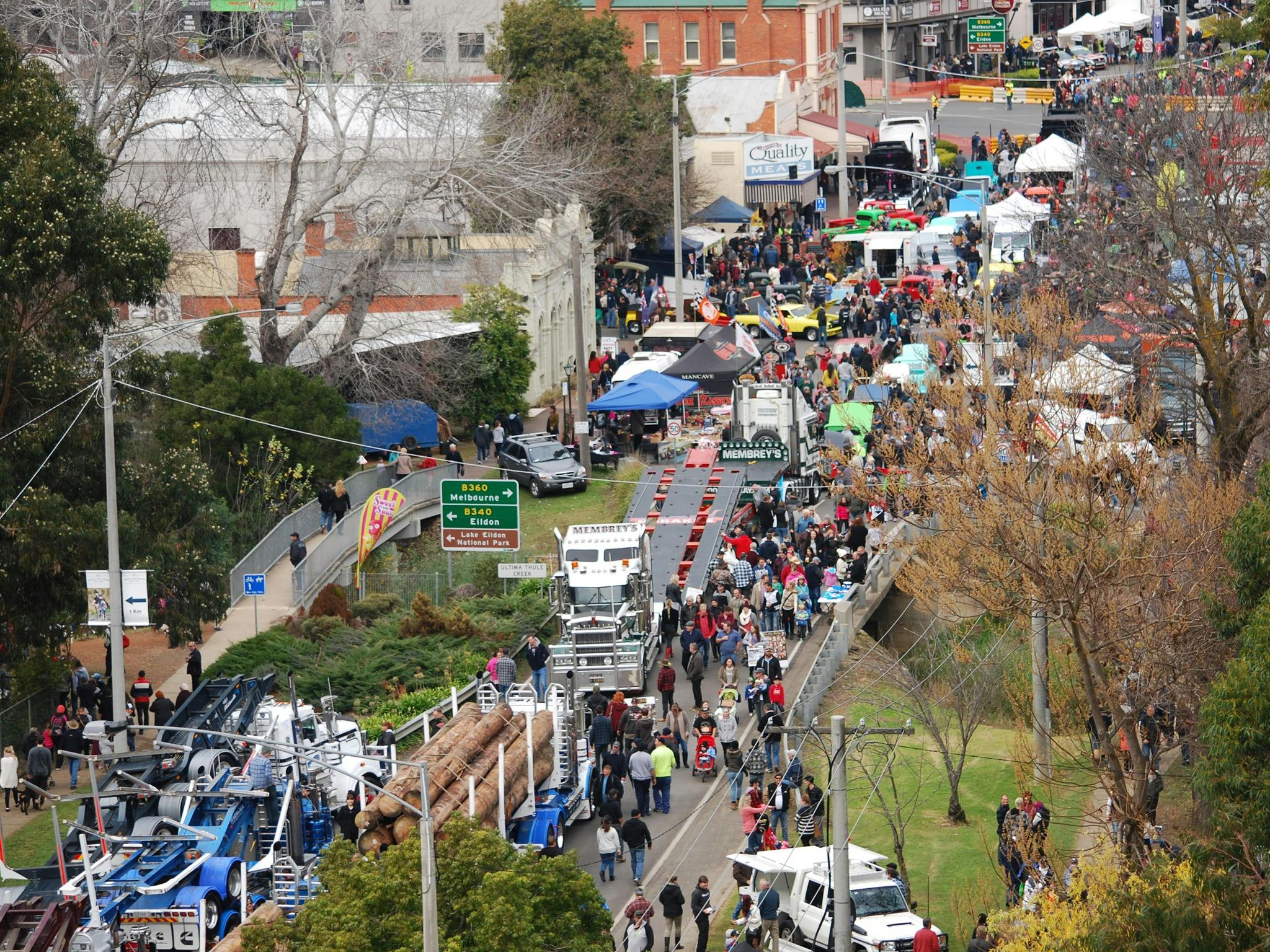 Aerial photo of logging trucks and crowds in street