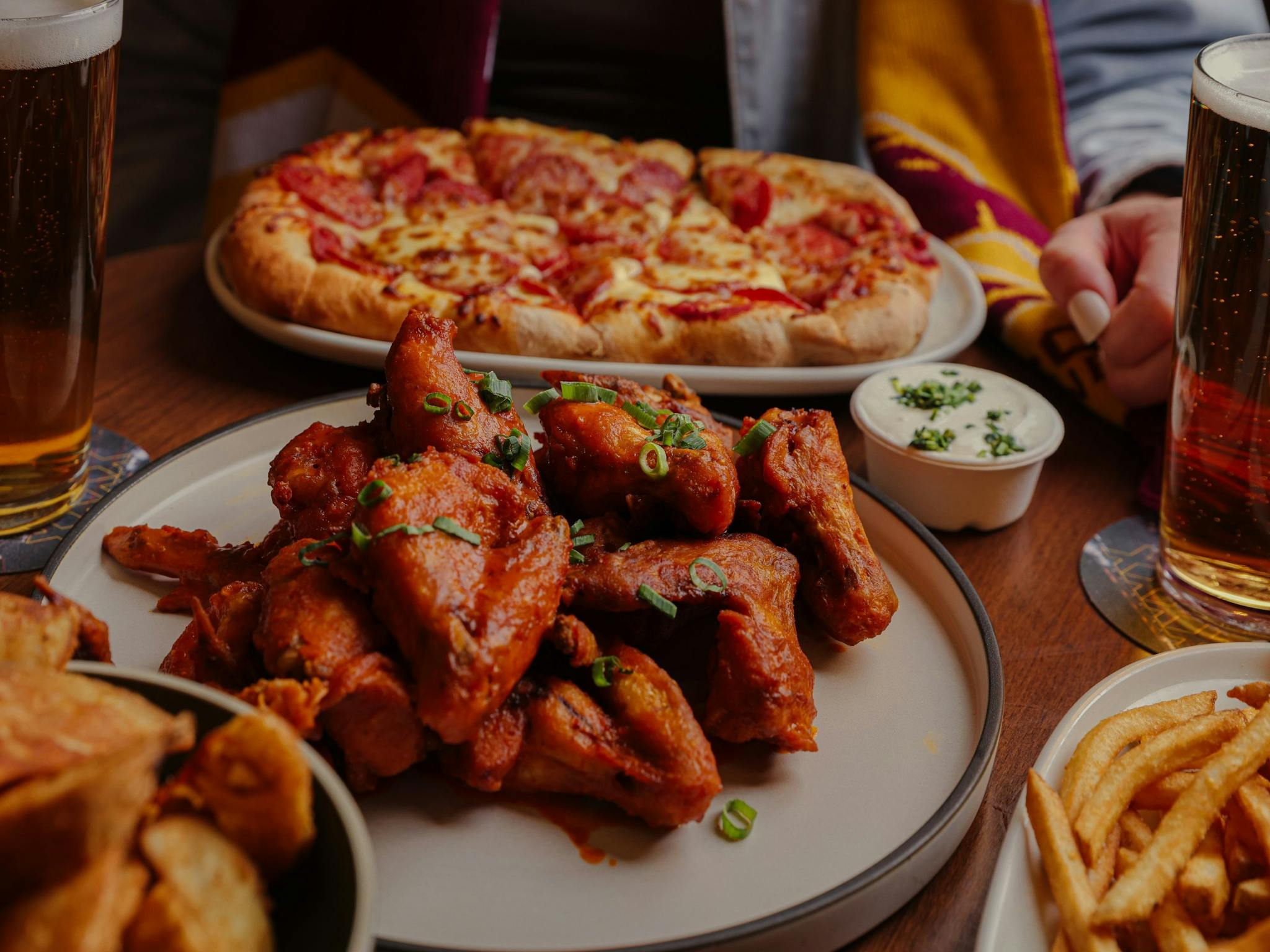 Wings and pizzas on a table Wings and pizzas on a table