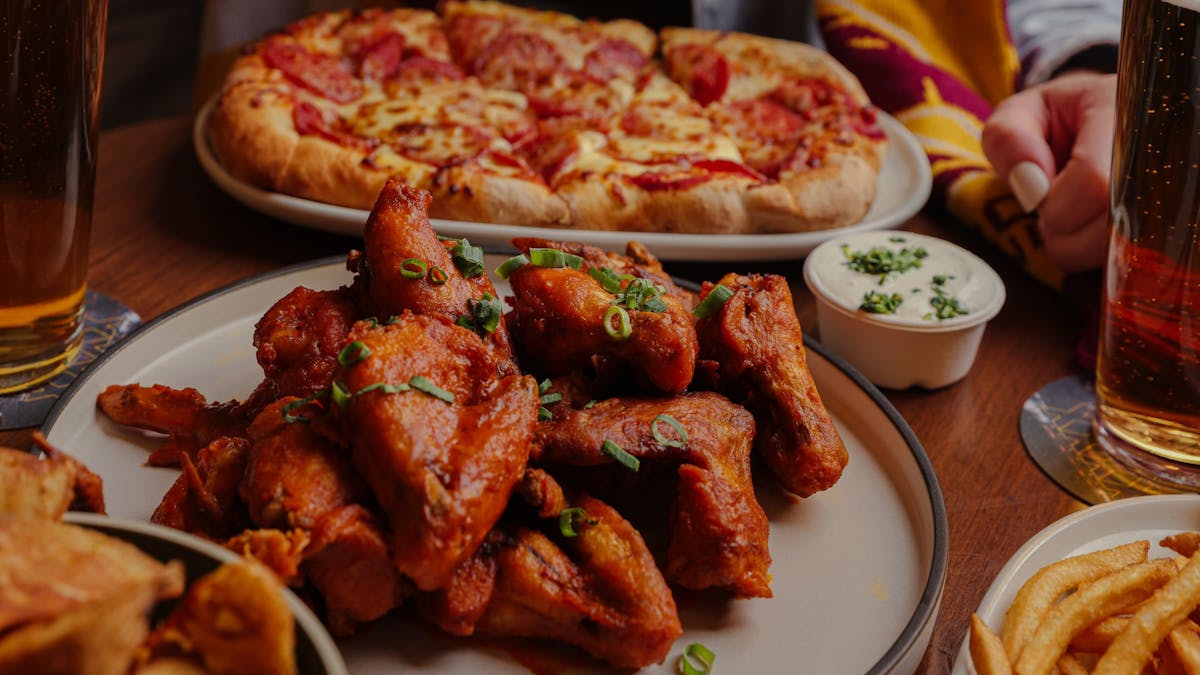 Wings and pizzas on a table