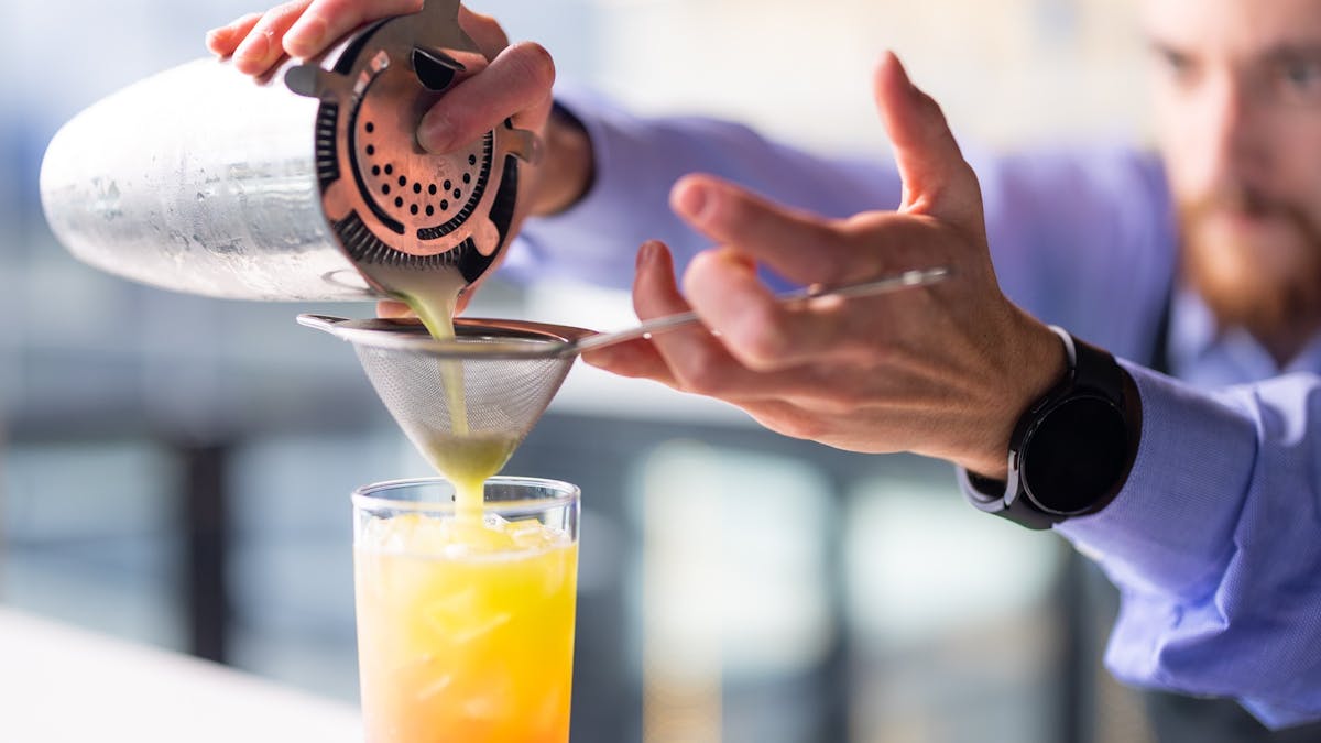 Cocktail being poured at bar
