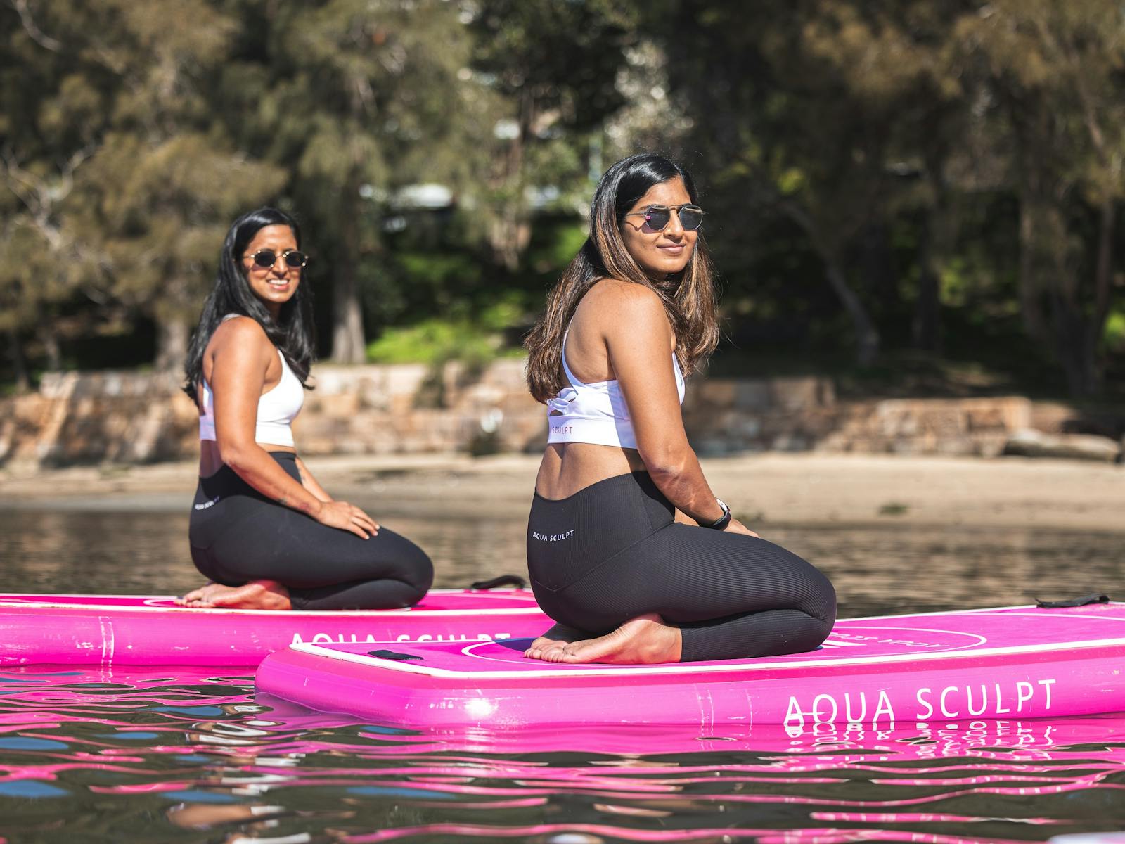 Two sisters sitting on their Aqua Sculpt boards waiting for the Pilates class to start