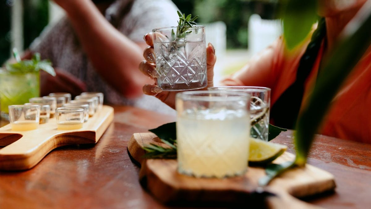 Guests seated at a tasting bench enjoying a guided gin tasting at Tamborine Mountain Distillery, sam