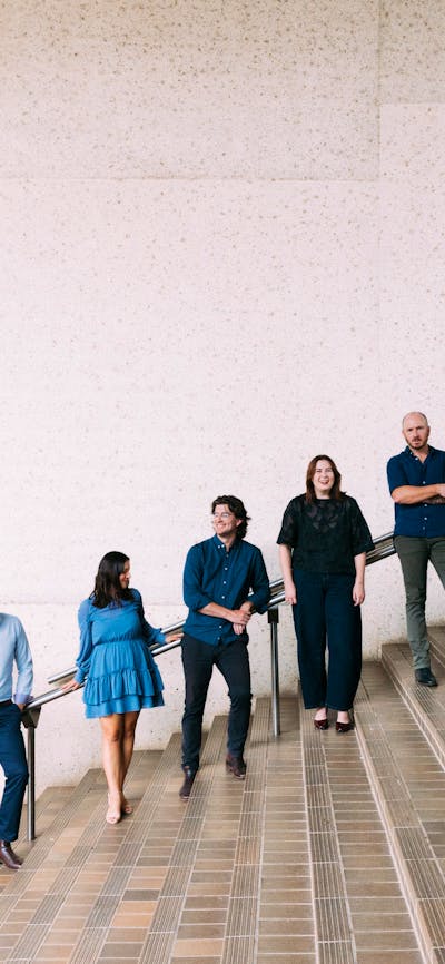 The six (6) singers of Luminescence Chamber Singers are photographed smiling at each other.