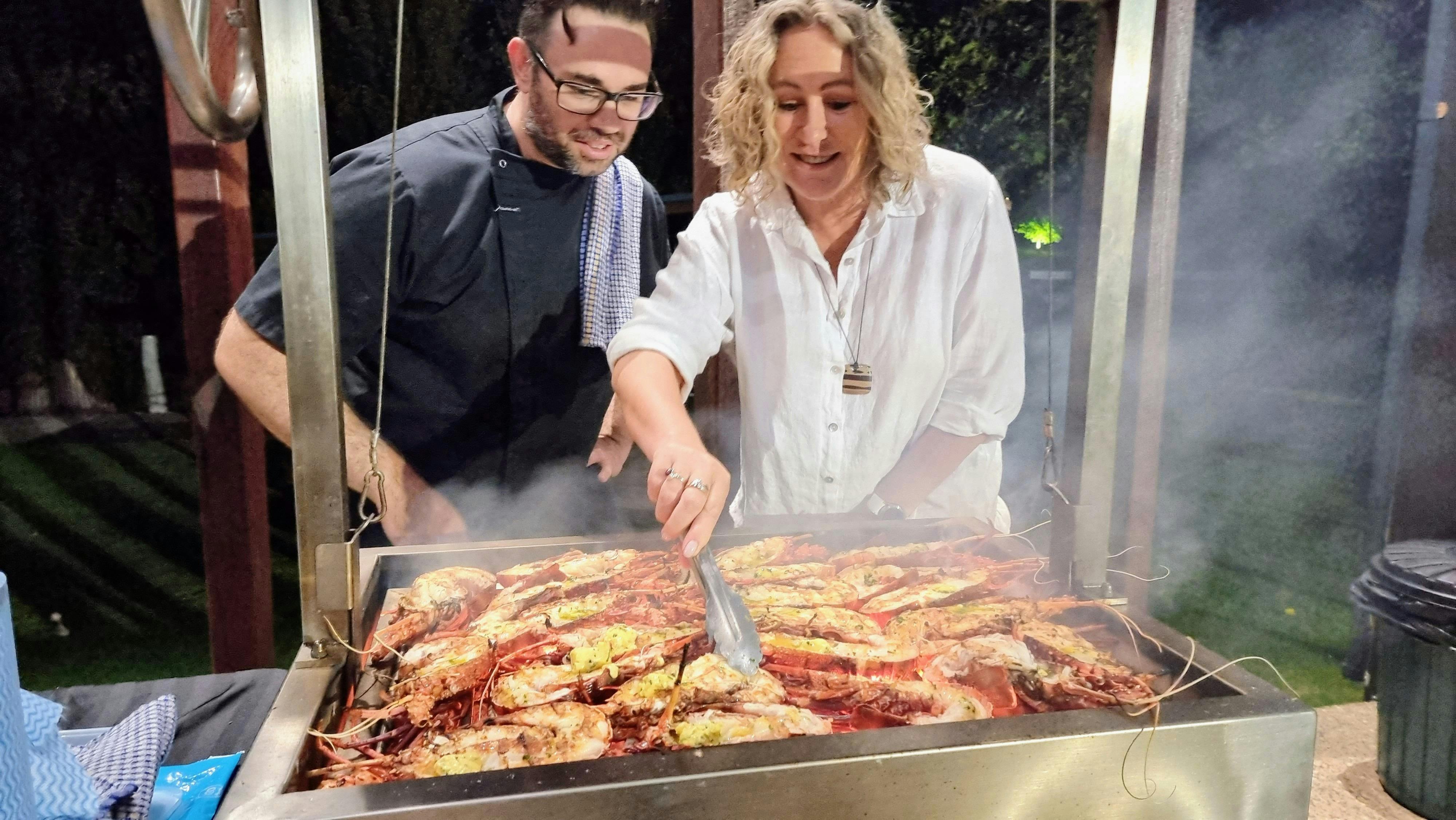 2 people cooking crayfish on the bbq