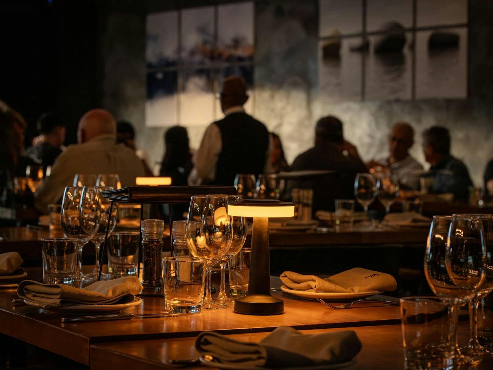 帶燈和酒杯的環境照明桌,背景中有人