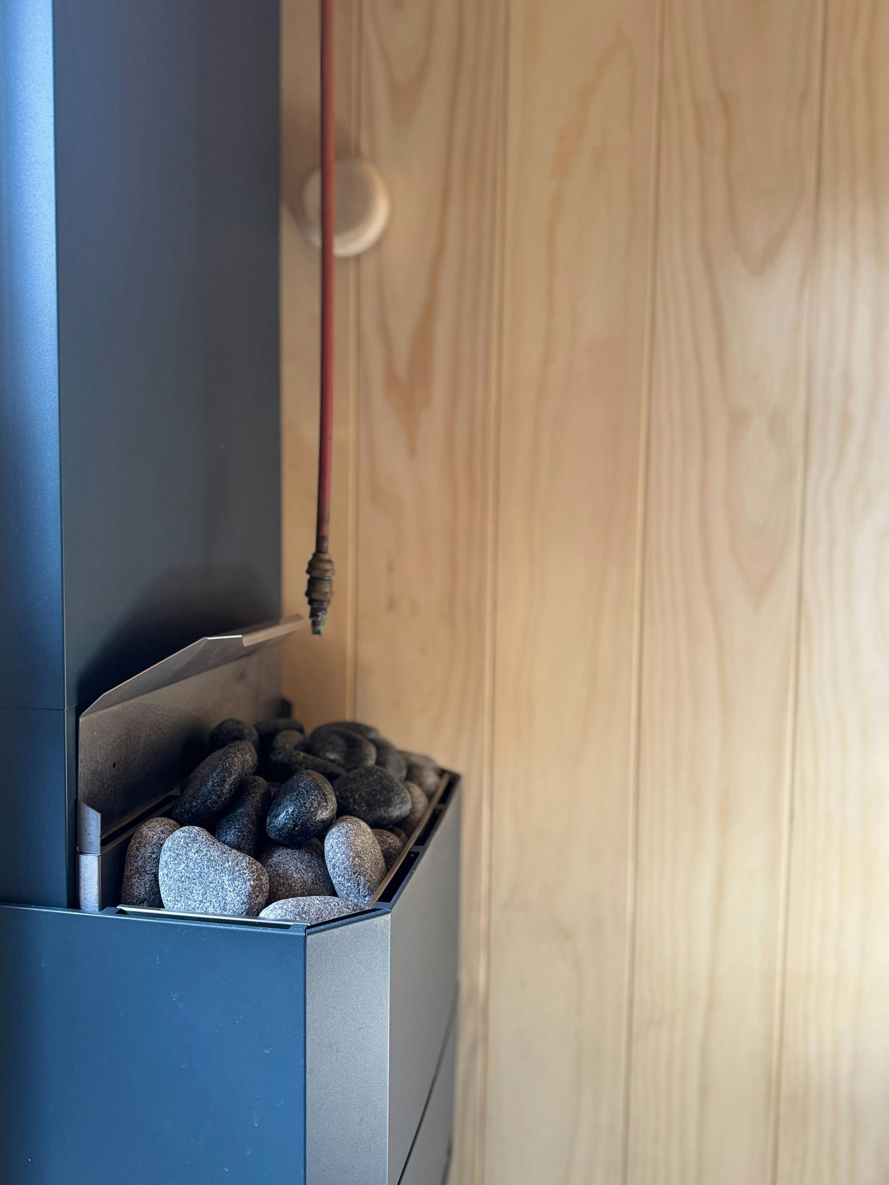 Close-up of sauna heater and hot stones inside the Sweaty Penguins sauna.
