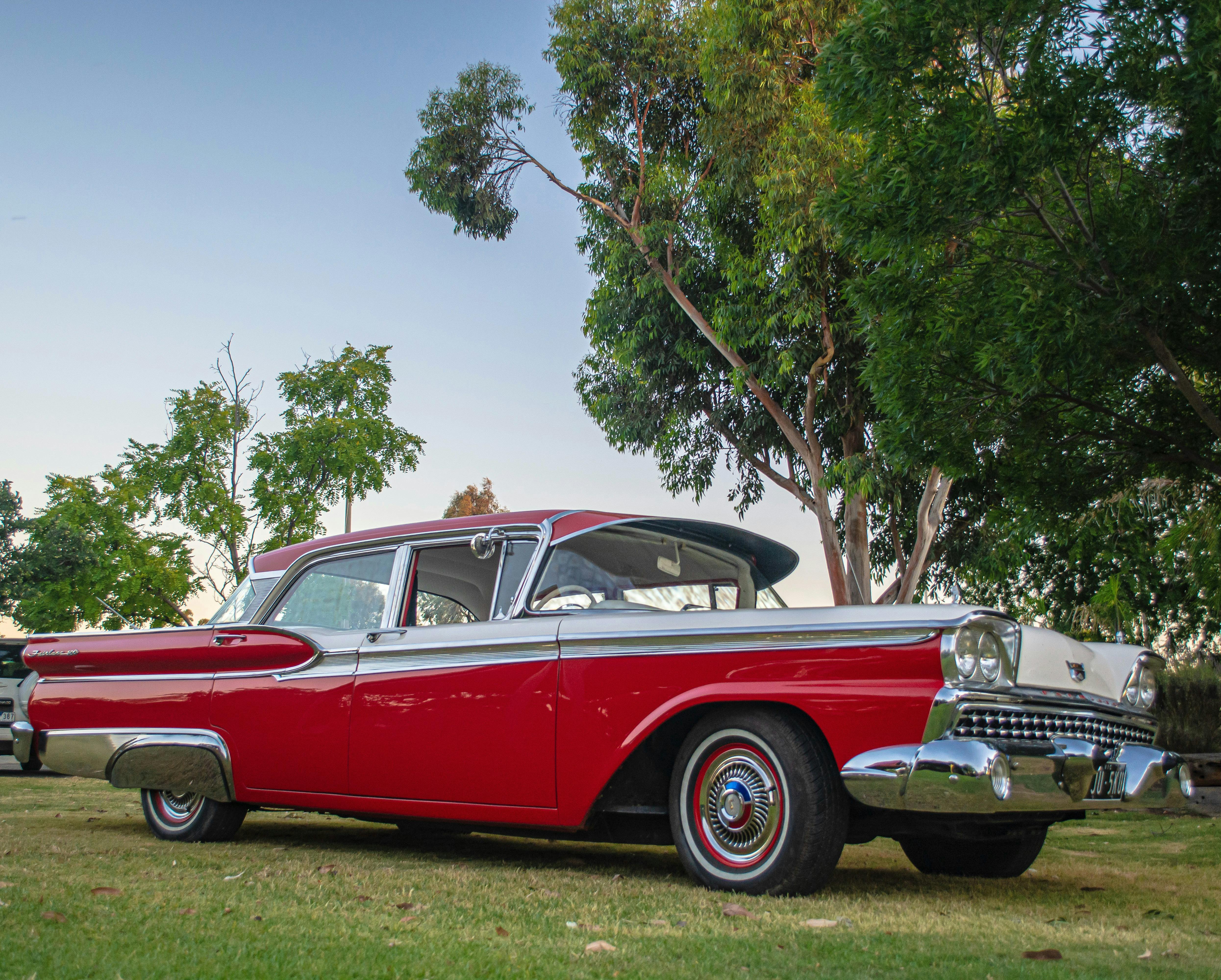Four door 1959 Ford Fairlane two toe red and white.