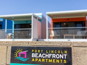 Beachfront Apartment deck showing deck furniture, and lawned area.