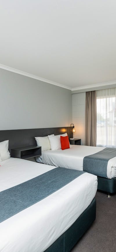 Twin Double Room layout, featuring two double beds, desk, kitchenette and modern design.