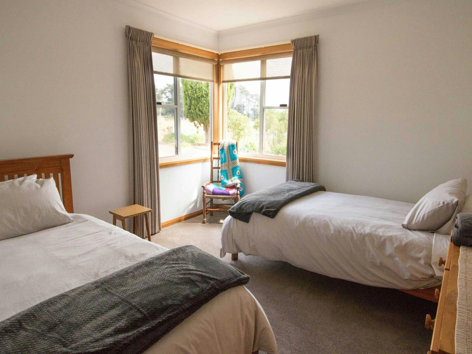 Twin bedroom with two single beds and windows looking out to front garden