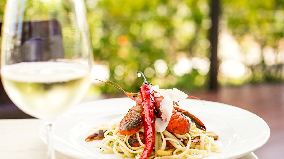 Linguini Pepperincino with red claw and a glass of wine