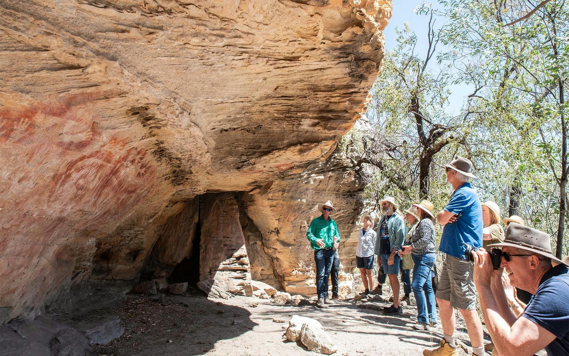 A group of Boobook Explore guests looking at Aboriginal rock art in the Carnarvon Ranges