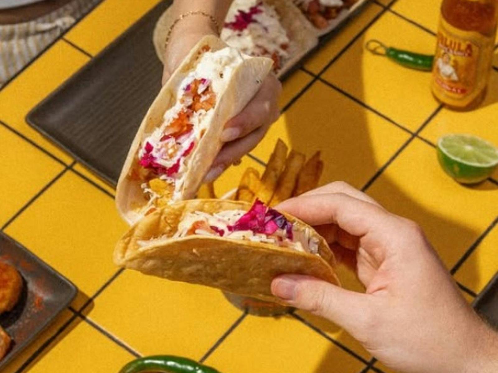 Two hands holding tacos