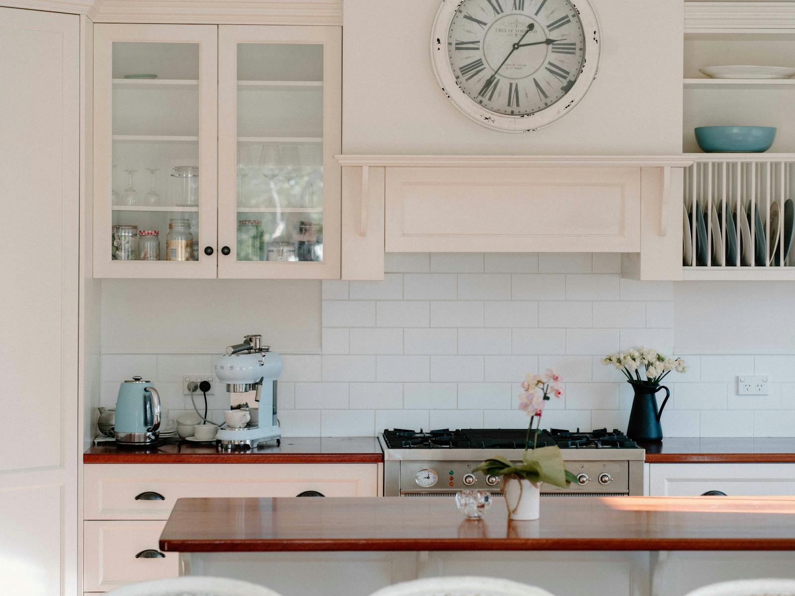 Country style kitchen featuring large antique clock and baby blue SMEG coffee machine
