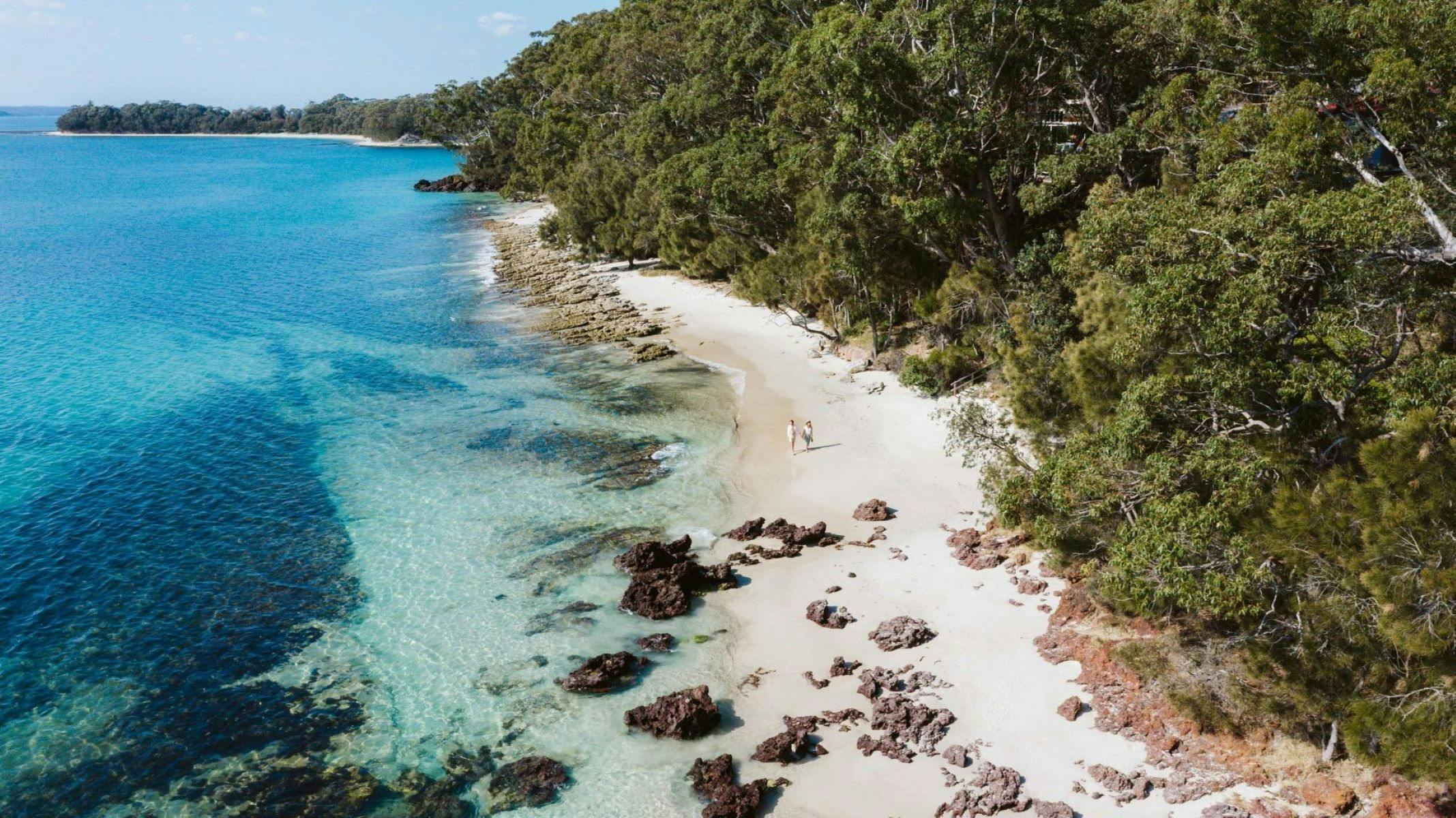 Image of beach in Vincentia where Beachstone property is located. Blue water and rocks along beach.