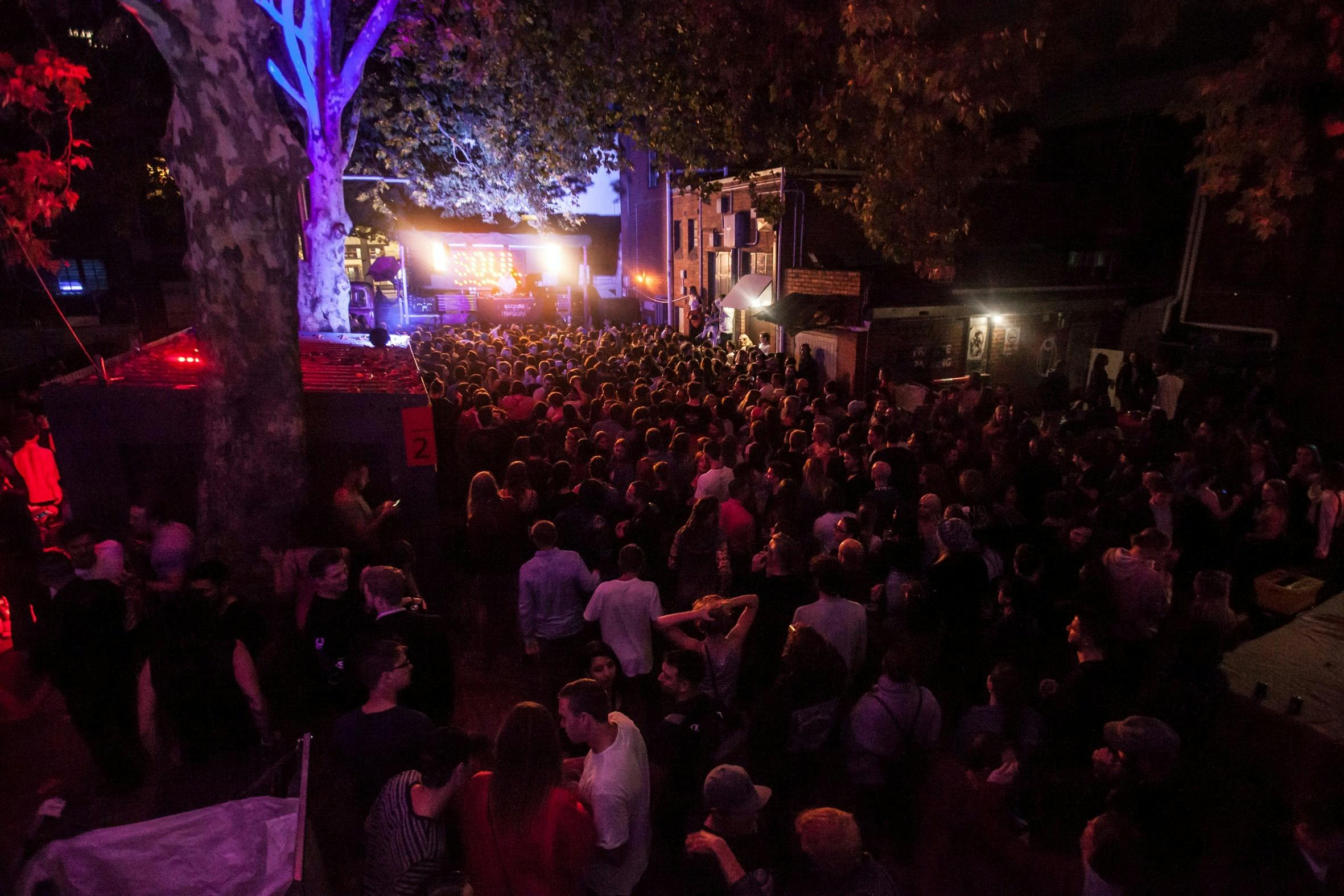 Crowd of people dancing at an outdoor stage